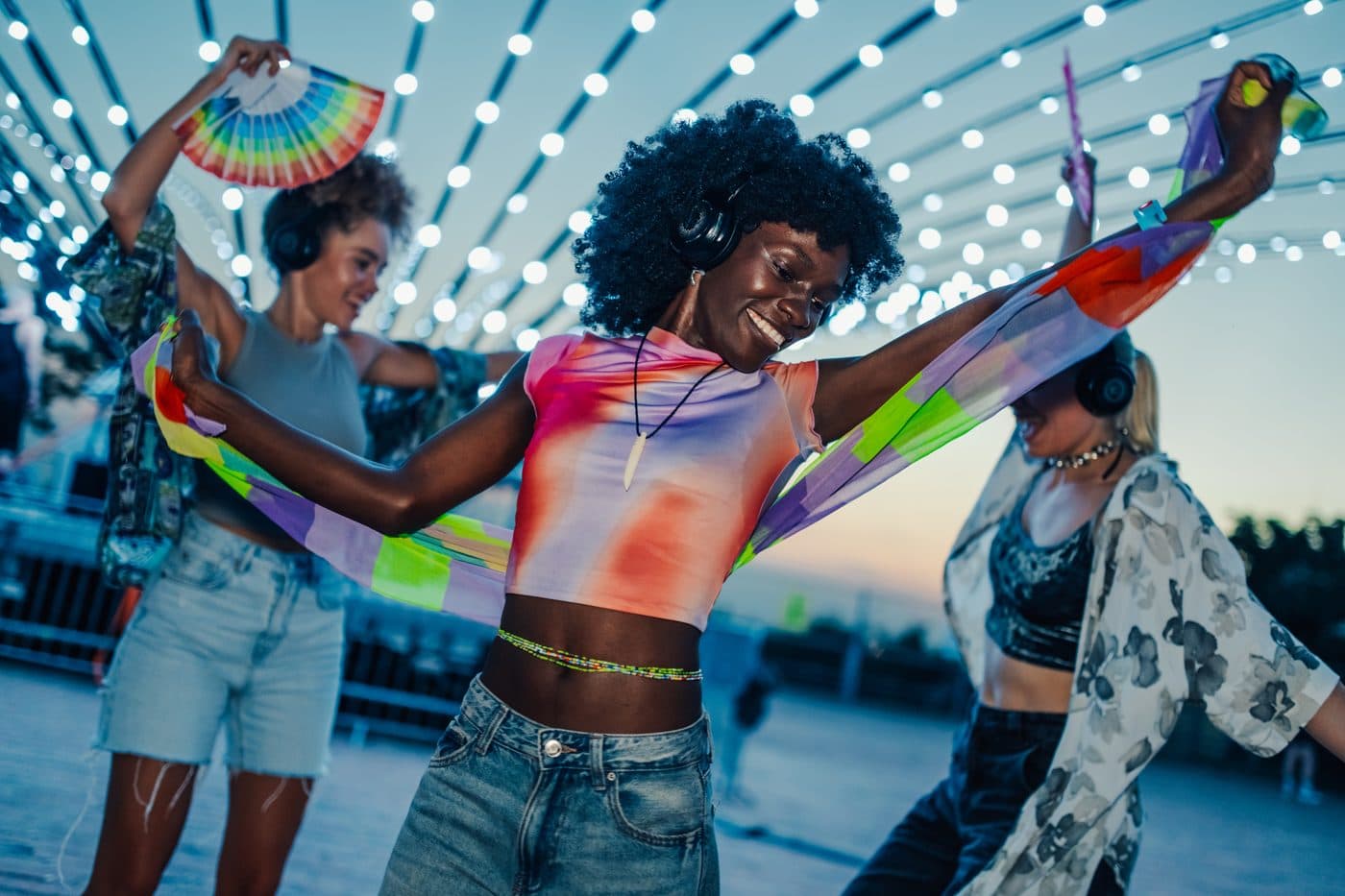 Friends dancing to music outdoors at night